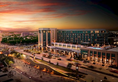 A modern city plaza with a large building, wide steps, and warm sunset skies casting a golden glow over the scene.