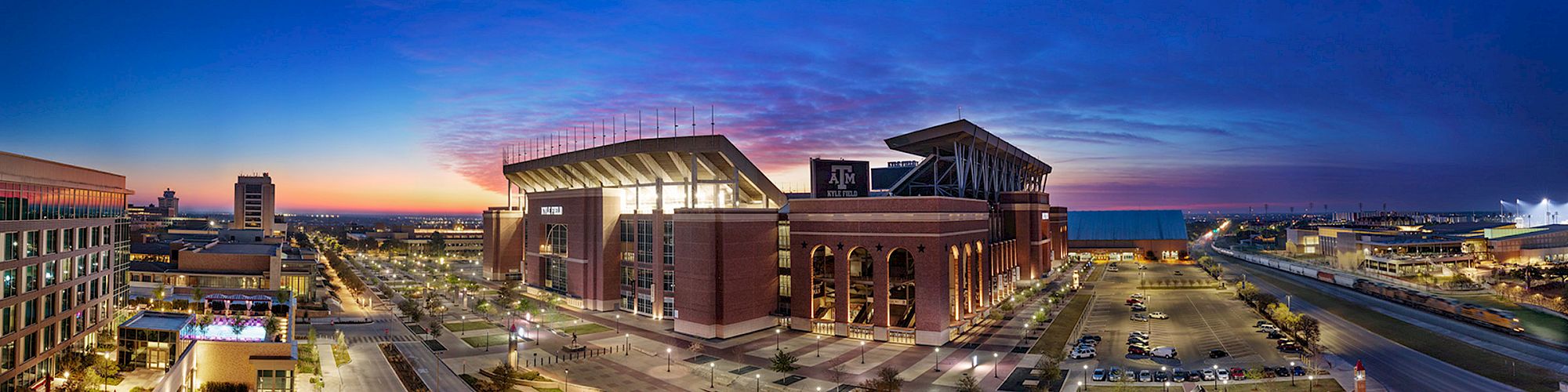 Panoramic view of Kyle Field with a sunset in the background from the penthouse balcony