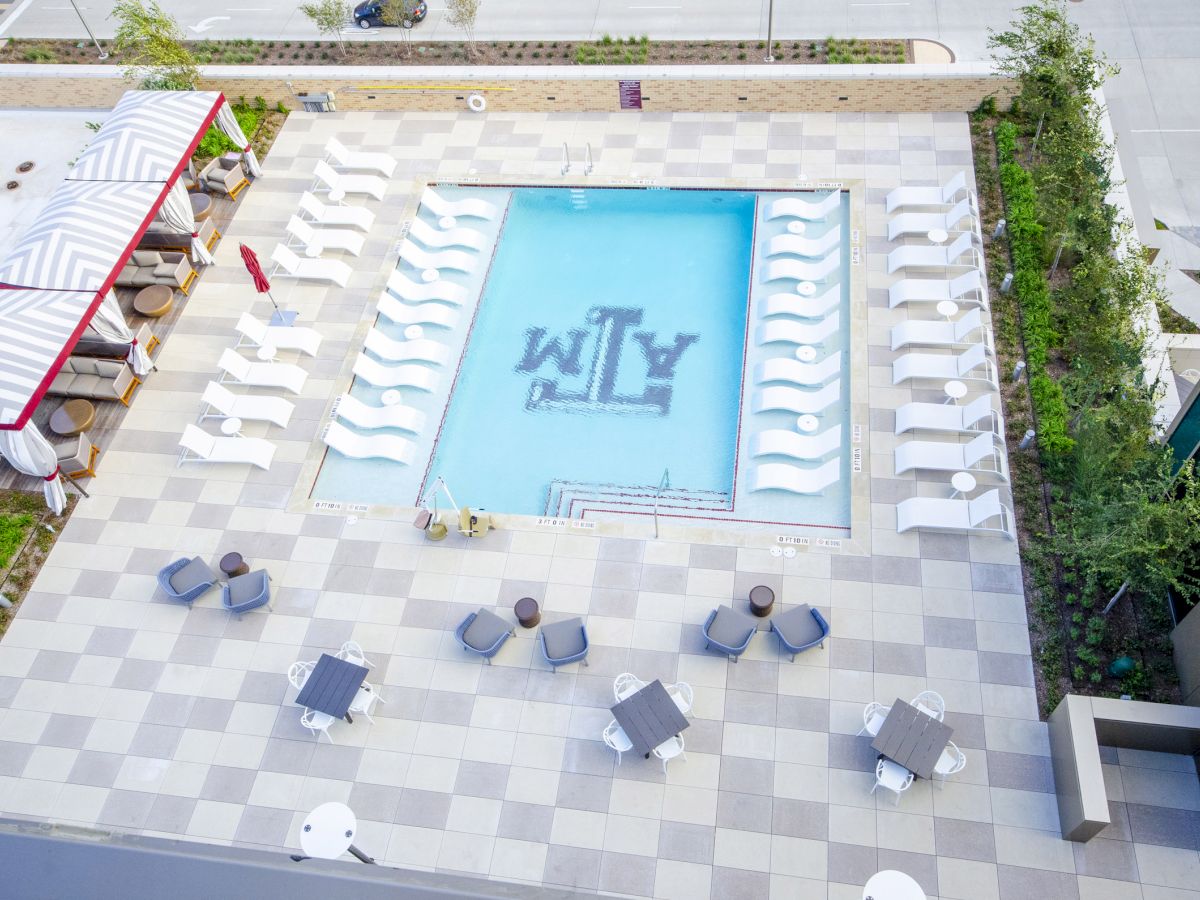 Aerial view of rooftop pool with Block T logo in center.
