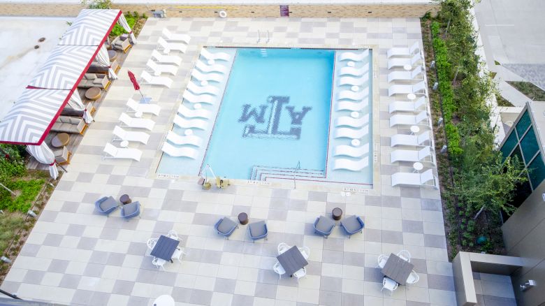 Aerial view of rooftop pool with Block T logo in center.