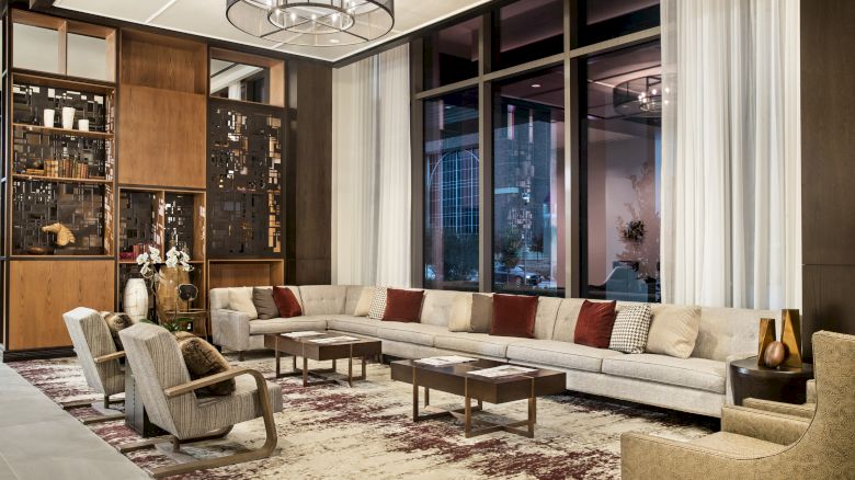 Hotel Lobby with a large grey couch in front of floor length windows