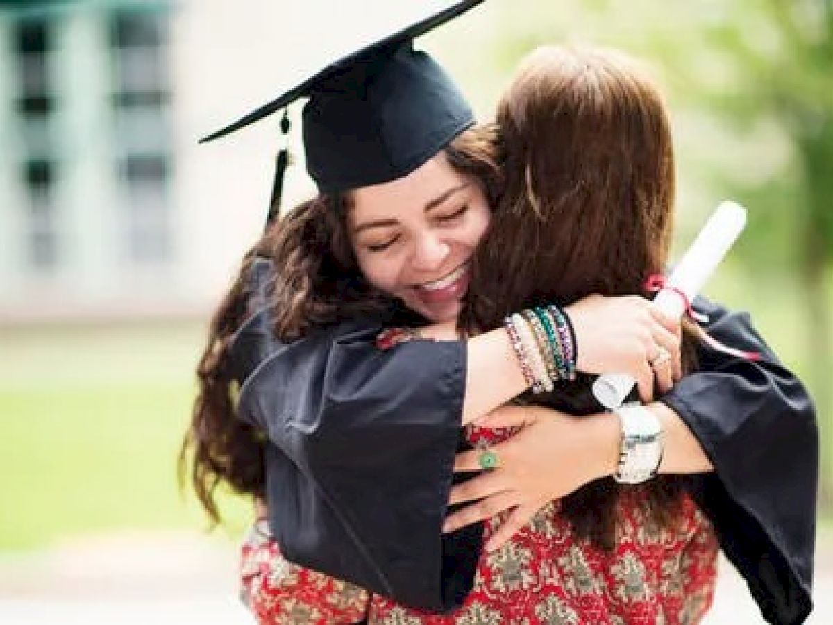 Graduate and friend embracing