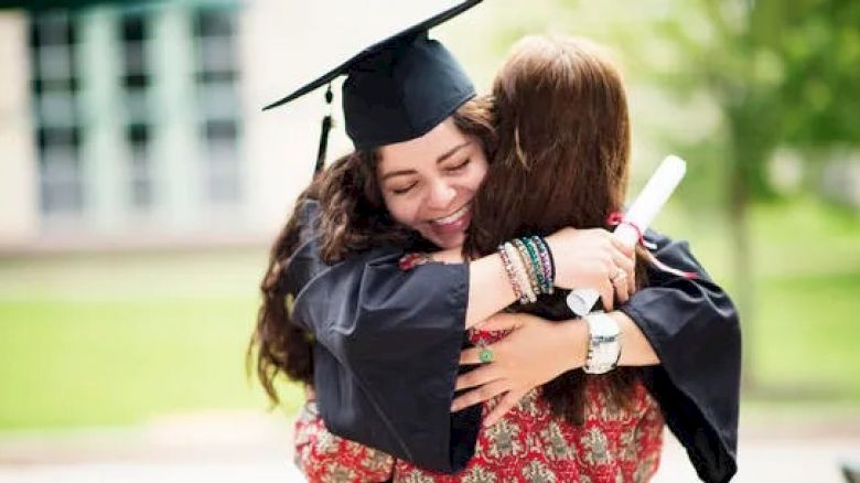 Graduate and friend embracing
