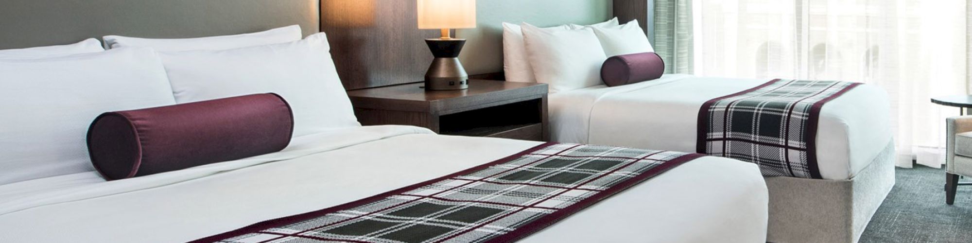 Modern hotel room with black and white images above bed and two full-size beds