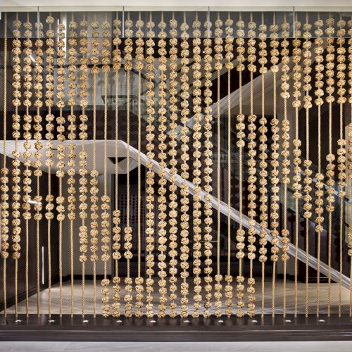 This image shows a decorative installation with rows of spherical objects hanging on strings, creating a textured pattern.