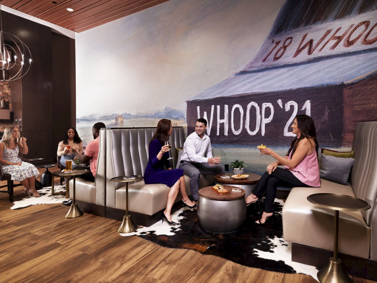 adults enjoying cocktails and food at The Rail in sitting area