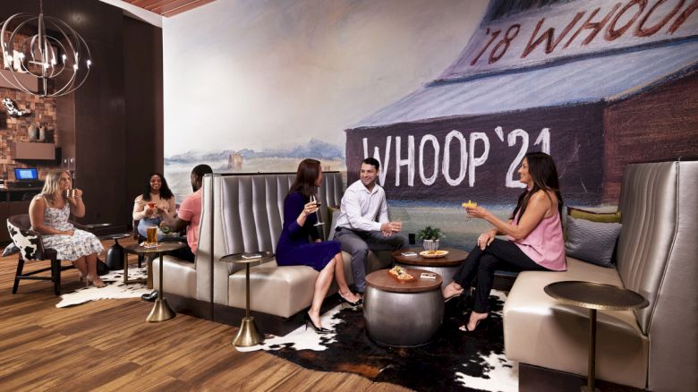 adults enjoying cocktails and food at The Rail in sitting area