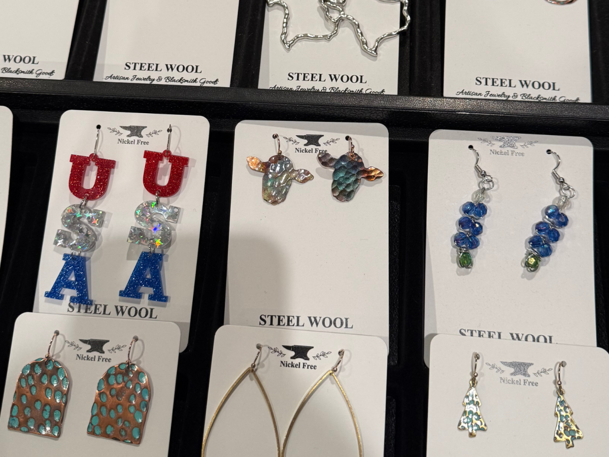 The image displays various earrings on display cards, including USA-themed ones and others with unique designs labeled "Steel Wool."