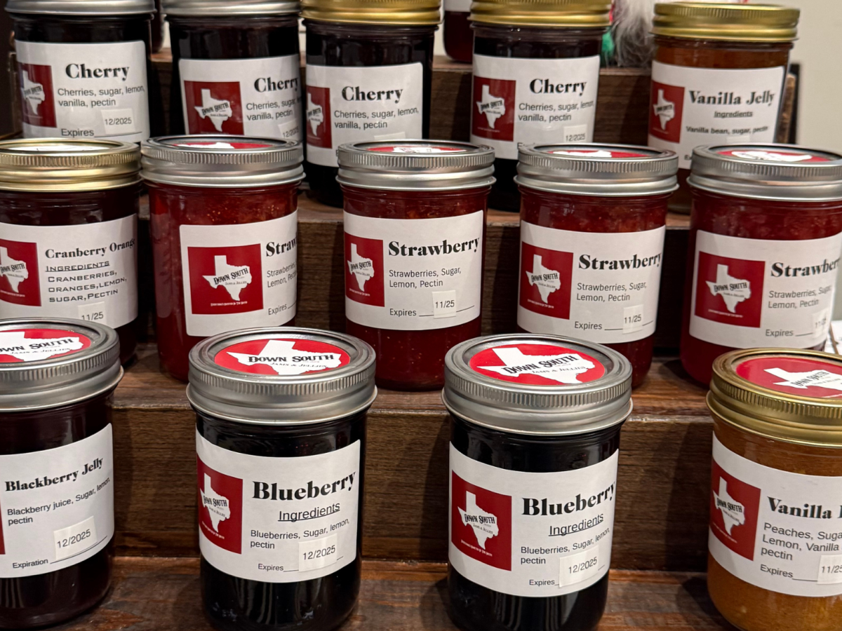 Jars of various fruit jams labeled with Texas-themed designs are displayed, including cherry, cranberry, strawberry, blueberry, and vanilla pear.